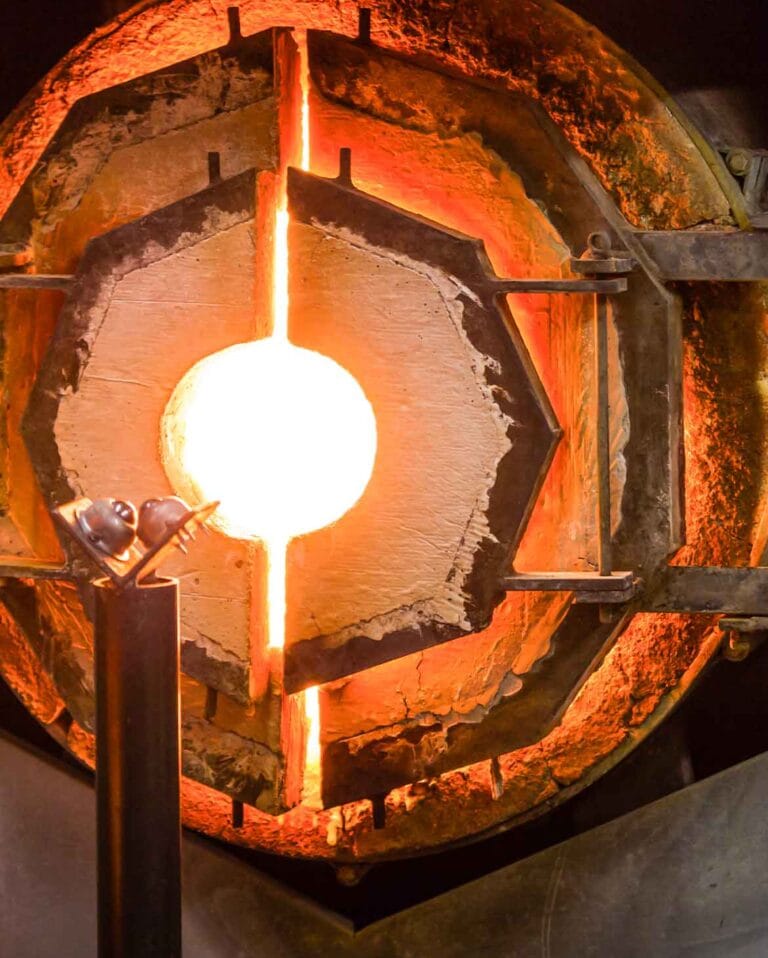 Forno industrial para sopro de vidro com interior incandescente, uma das principais fontes de calor radiante no ambiente de trabalho.