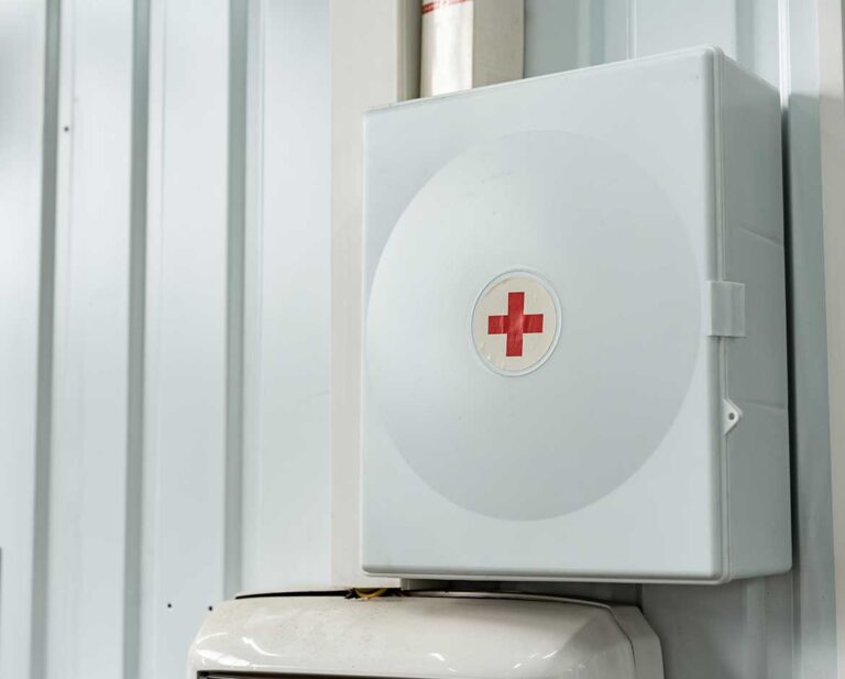 kit de primeiros socorros para queimaduras instalado em parede de metal industrial.