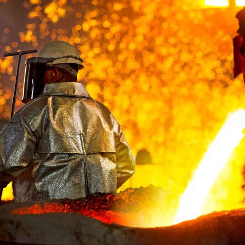 trabalhador em fundição utilizando vestimenta aluminizada de proteção térmica regida pela norma iso 11612 durante o vazamento de metal fundido