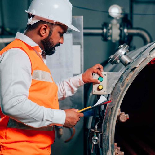 profissional-de-sst-com-capacete-e-prancheta-inspeciona-forno-industrial-com-calor-intenso-que-exige-avaliacao-pelo-nr-15-anexo-3